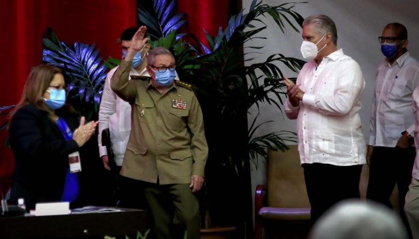 Raúl Castro, primer secretario del Partido Comunista y expresidente de Cuba, saluda a los miembros en la sesión inaugural del VIII Congreso del Partido Comunista de Cuba, mientras el presidente cubano Miguel Díaz-Canel, derecha, aplaude en el Palacio de Convenciones, en La Habana, Cuba, el viernes 16 de abril de 2021. (Ariel Ley Royero/ACN vía AP)